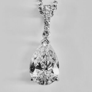 Pear-shaped diamond pendant on silver chain.